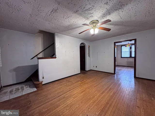 a view of a livingroom with wooden floor and a ceiling fan