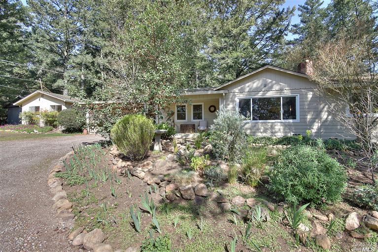 a front view of house with yard and trees around