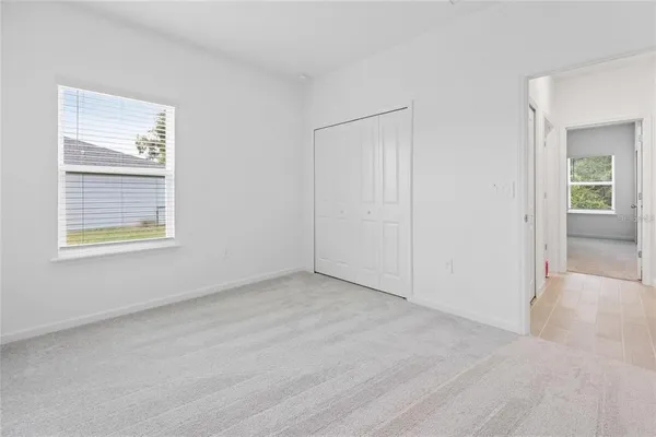 a view of a bedroom with a bed and a window