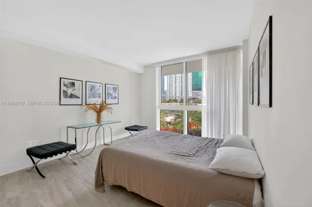 a bedroom with a large bed and a potted plant