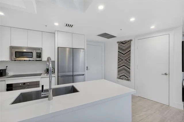 a kitchen with stainless steel appliances a refrigerator and a stove top oven