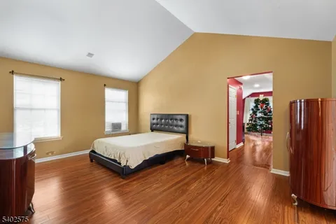 a spacious bedroom with a bed and wooden floor