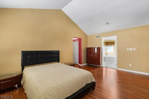 a bedroom with a bed and wooden floor
