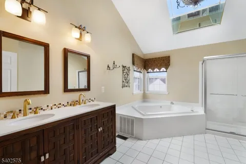 a bathroom with a double vanity sink mirror and bathtub