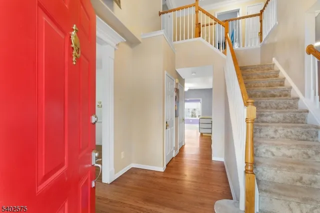 a view of a hallway with wooden floor and staircase