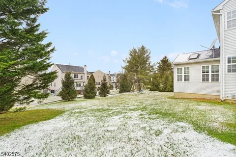 a view of a house with a big yard and large trees