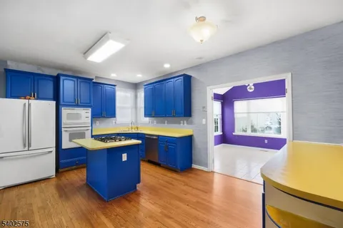 a kitchen with granite countertop wooden floors and stainless steel appliances