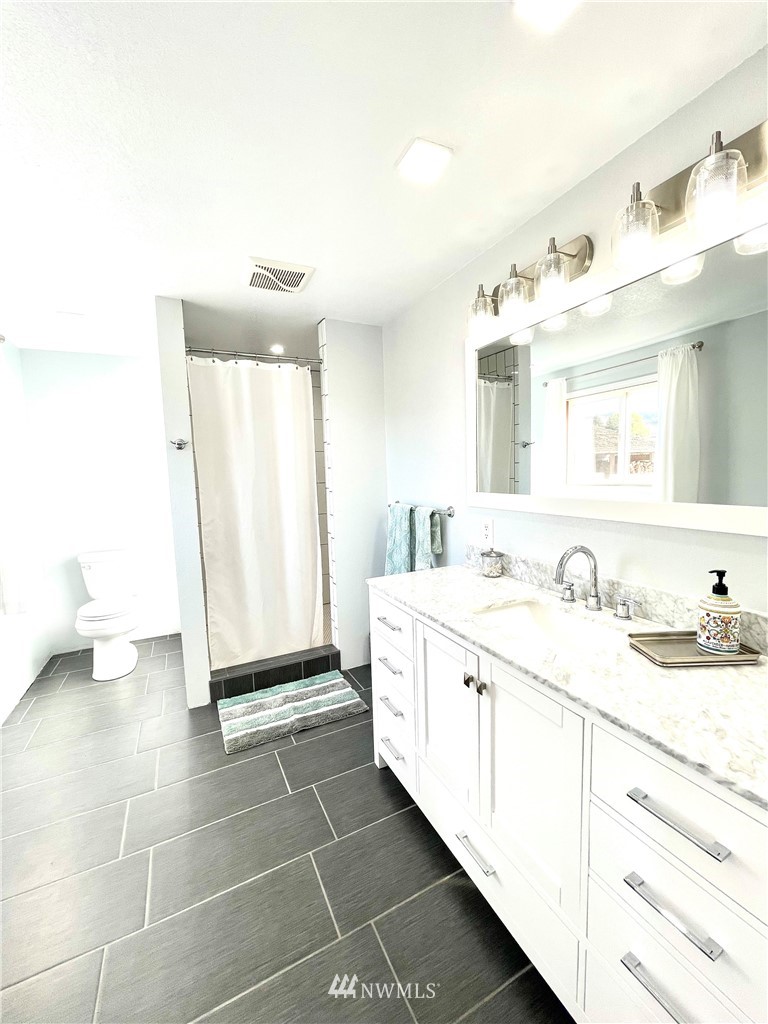 28 Dixon Road Omak, WA 98841 - Photo 18 of 39 a spacious bathroom with a double vanity sink and a mirror