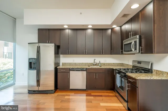 a kitchen with stainless steel appliances granite countertop a stove a sink and a refrigerator