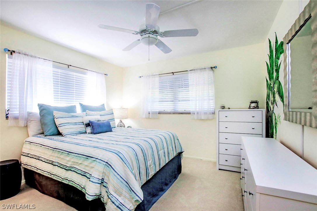 822 Beach Road Sanibel, FL 33957 - Photo 12 of 35 a bedroom with a bed and a chandelier