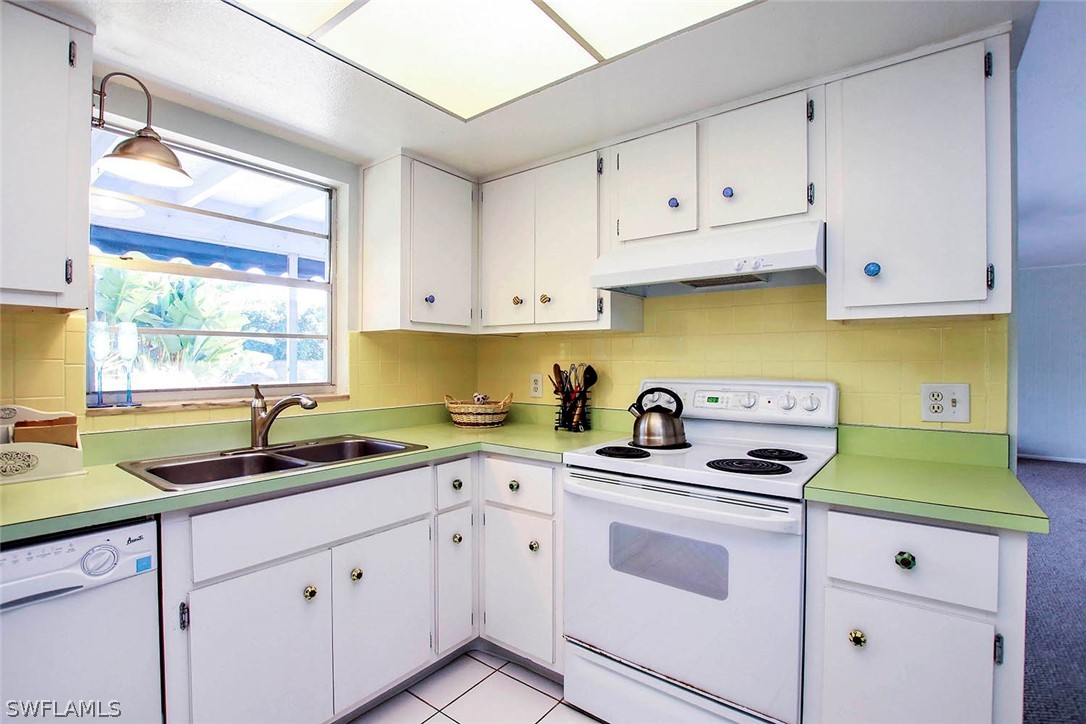 822 Beach Road Sanibel, FL 33957 - Photo 25 of 35 a kitchen with white cabinets sink and white appliances