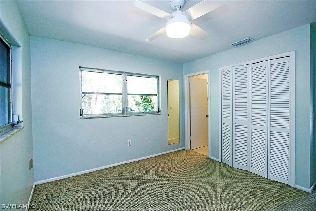 822 Beach Road Sanibel, FL 33957 - Photo 27 of 35 an empty room with chandelier fan and windows