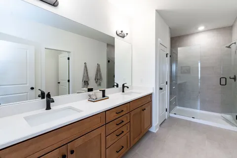 a bathroom with a double vanity sink mirror double and shower