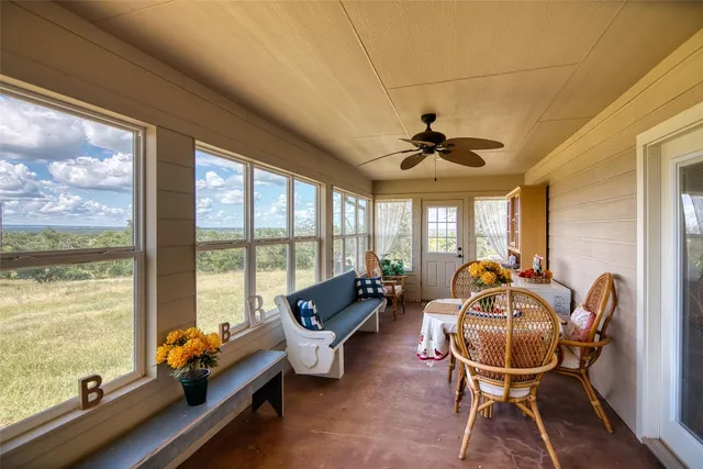 a living room with furniture and floor to ceiling windows