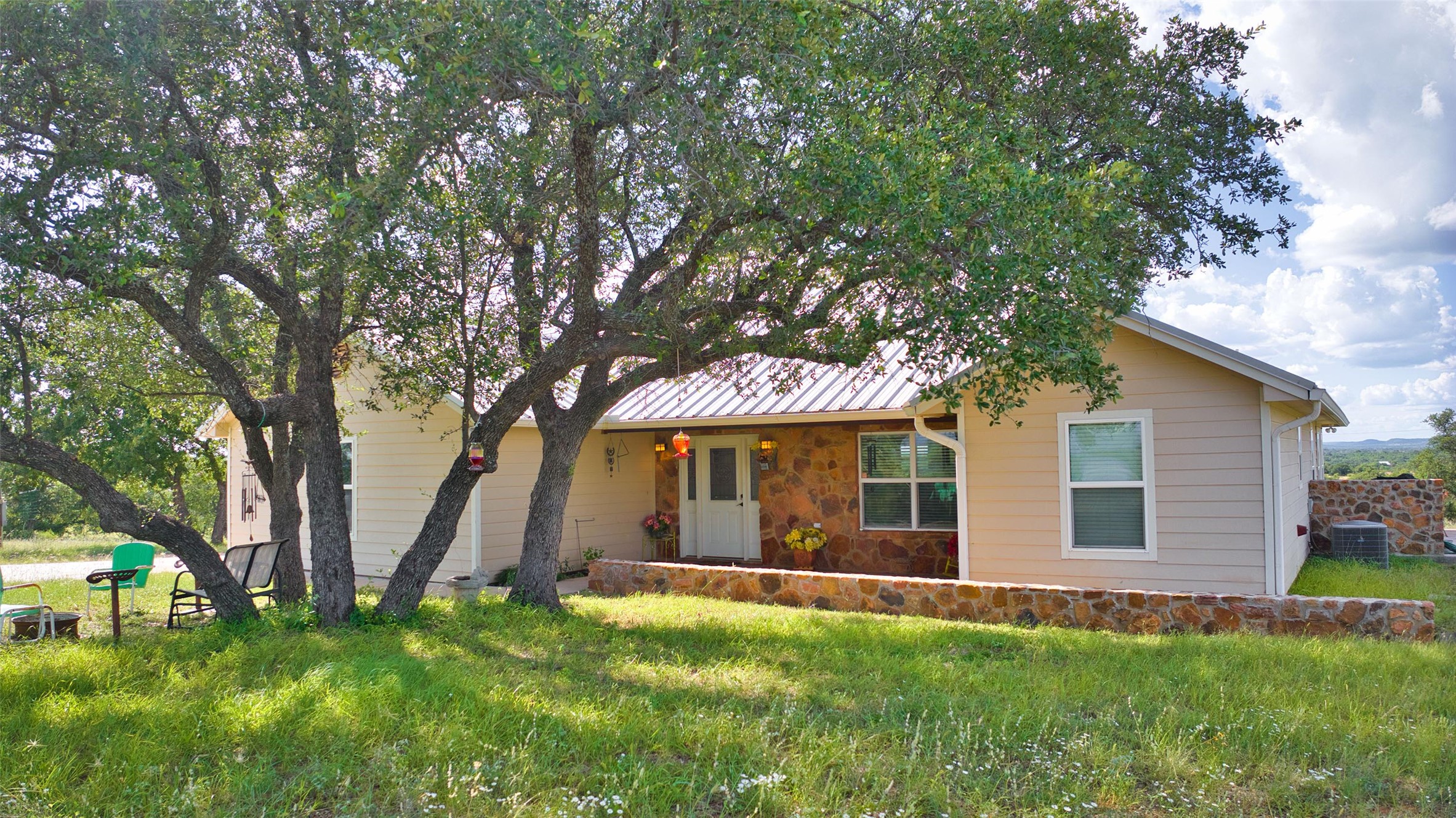 12119 Highway 29 Llano, TX 78643 - Photo 2 of 40 View of front of property featuring stone siding, a standing seam roof, and a metal roof