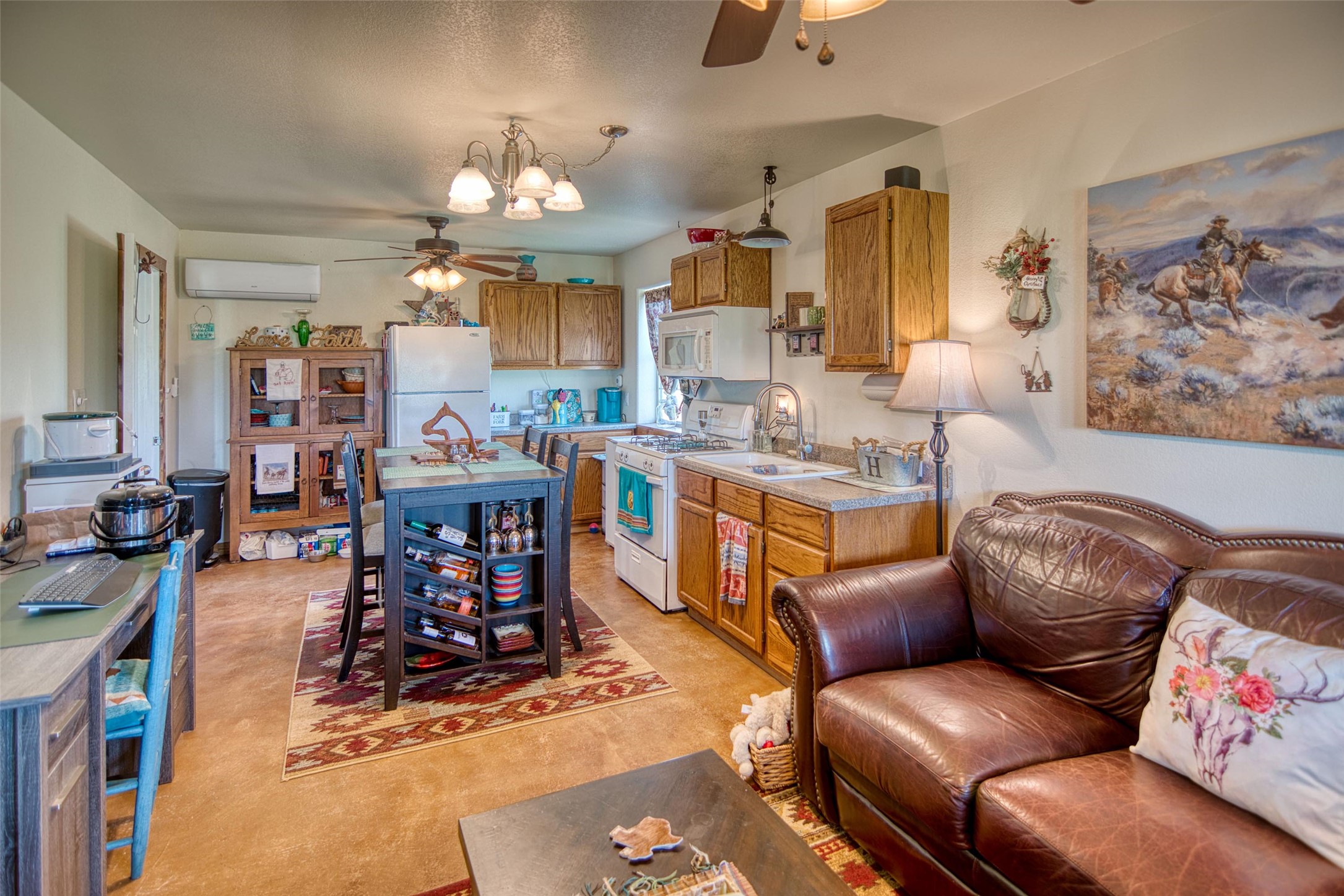 12119 Highway 29 Llano, TX 78643 - Photo 28 of 40 Kitchen featuring ceiling fan, white appliances, light countertops, brown cabinets, and a chandelier