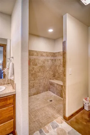 a bathroom with a granite countertop sink a mirror and a shower