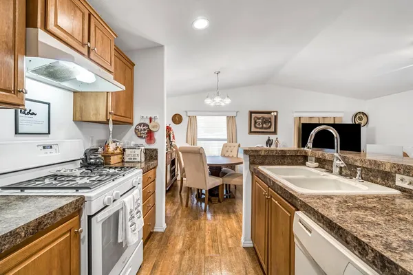 a kitchen with stainless steel appliances granite countertop a sink stove and cabinets