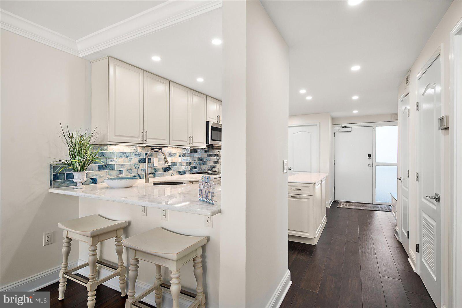 903 North Edgewater House Road Bethany Beach, DE 19930 - Photo 12 of 43 a kitchen with white cabinets and stainless steel appliances