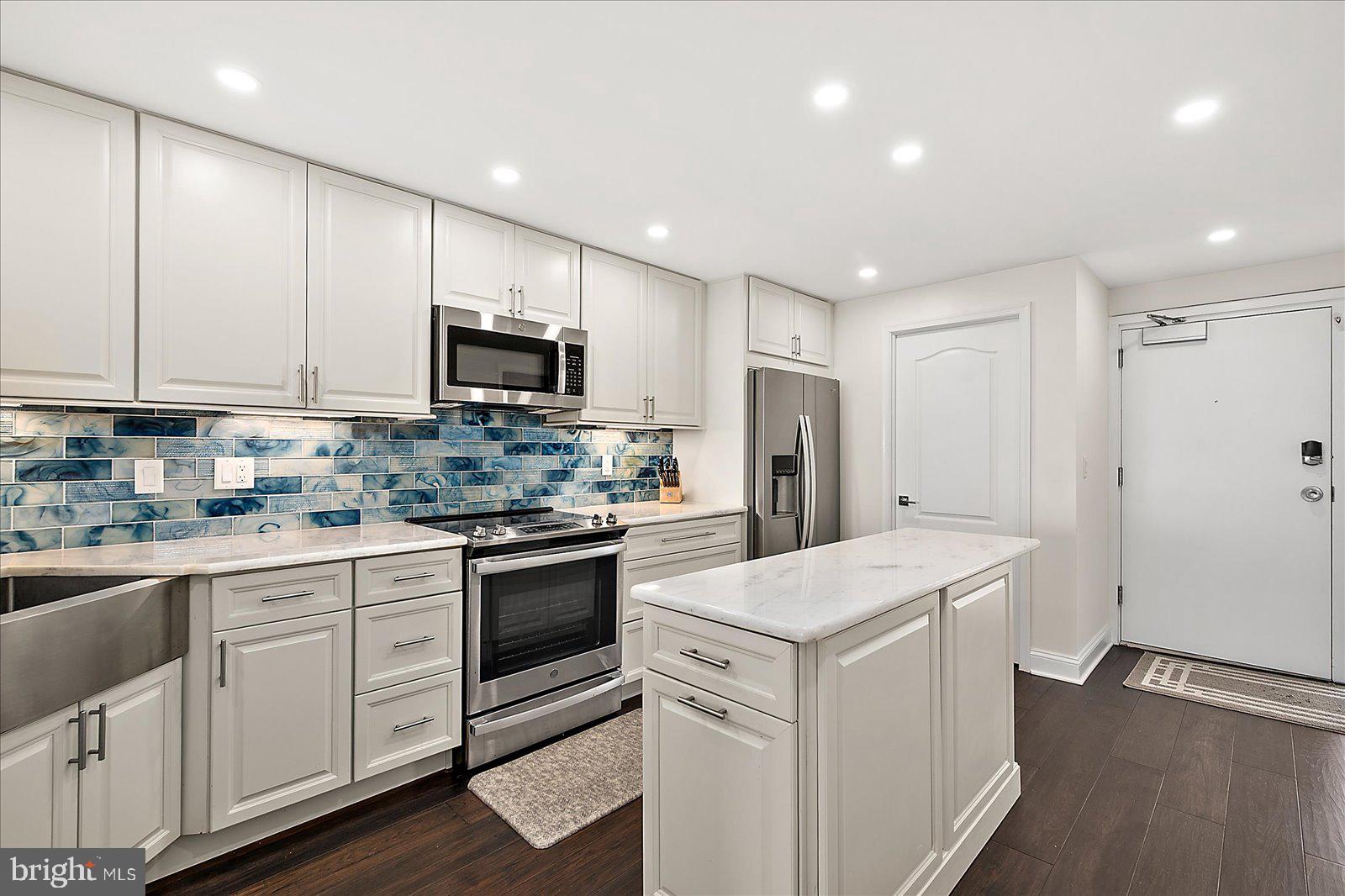 903 North Edgewater House Road Bethany Beach, DE 19930 - Photo 13 of 43 a kitchen with white cabinets and stainless steel appliances