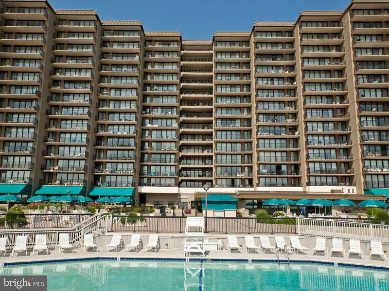 903 North Edgewater House Road Bethany Beach, DE 19930 - Photo 37 of 43 a front view of a building with glass windows and a table