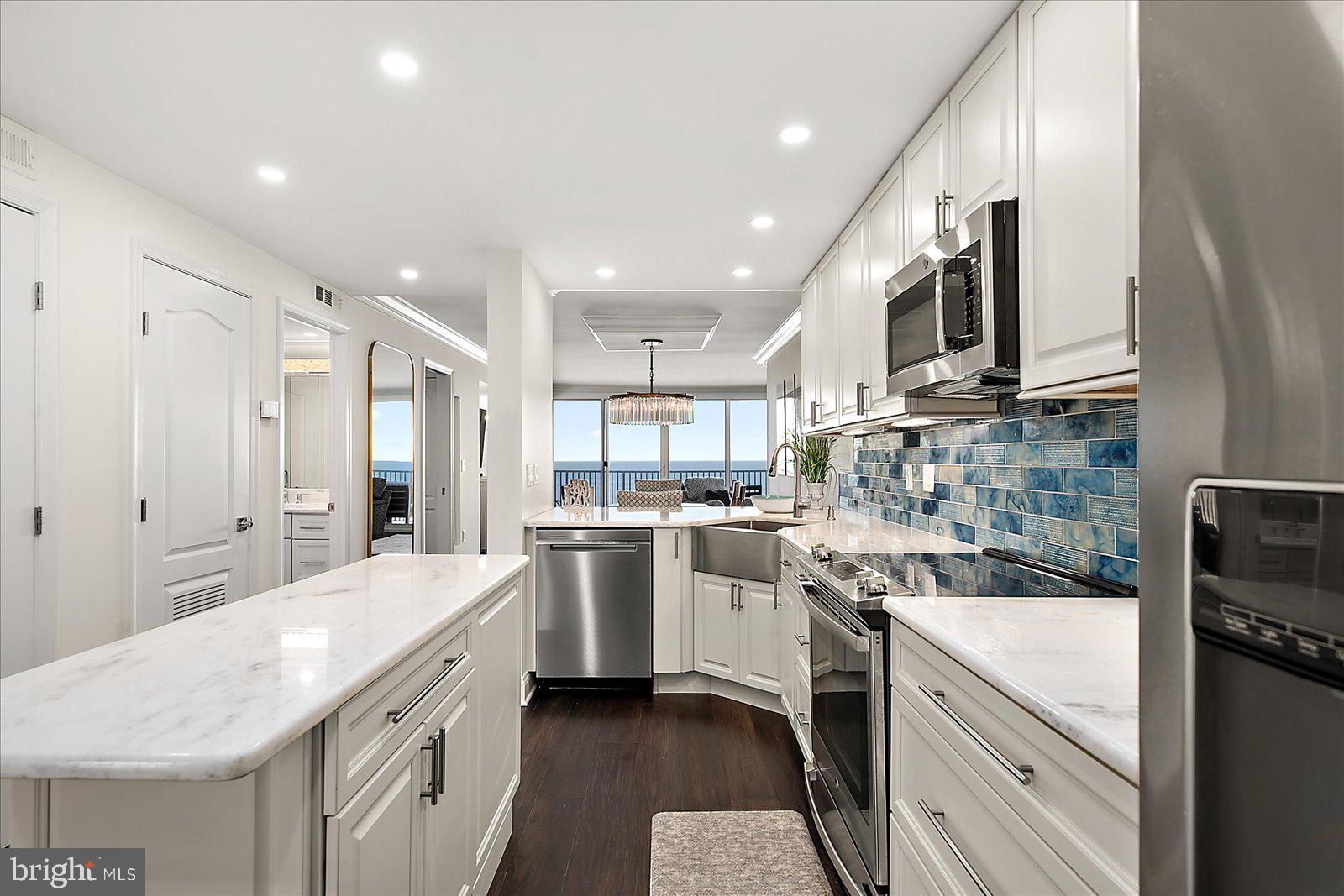 903 North Edgewater House Road Bethany Beach, DE 19930 - Photo 6 of 43 a kitchen with a sink stainless steel appliances and white cabinets