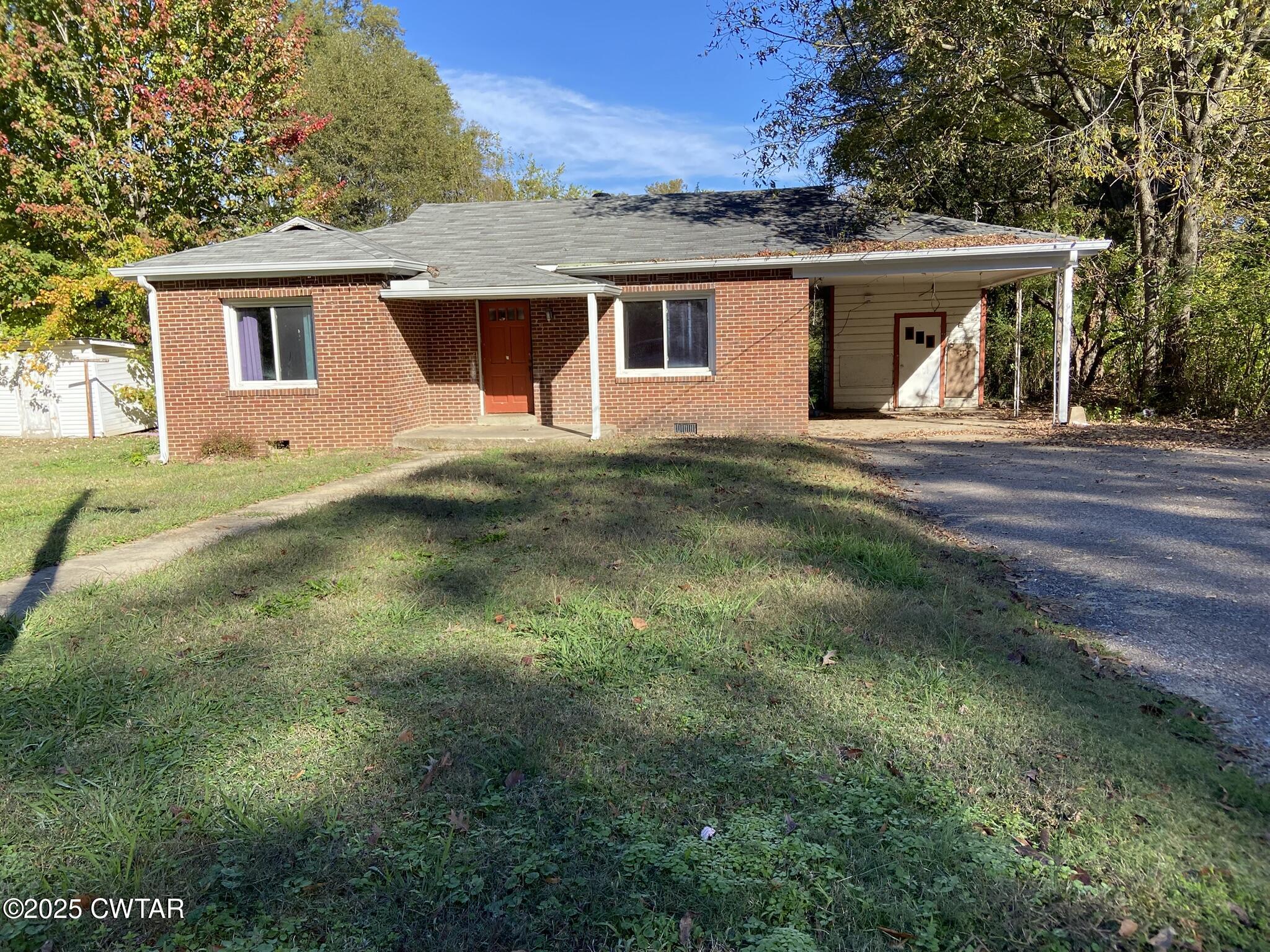 a front view of a house with a yard and trees