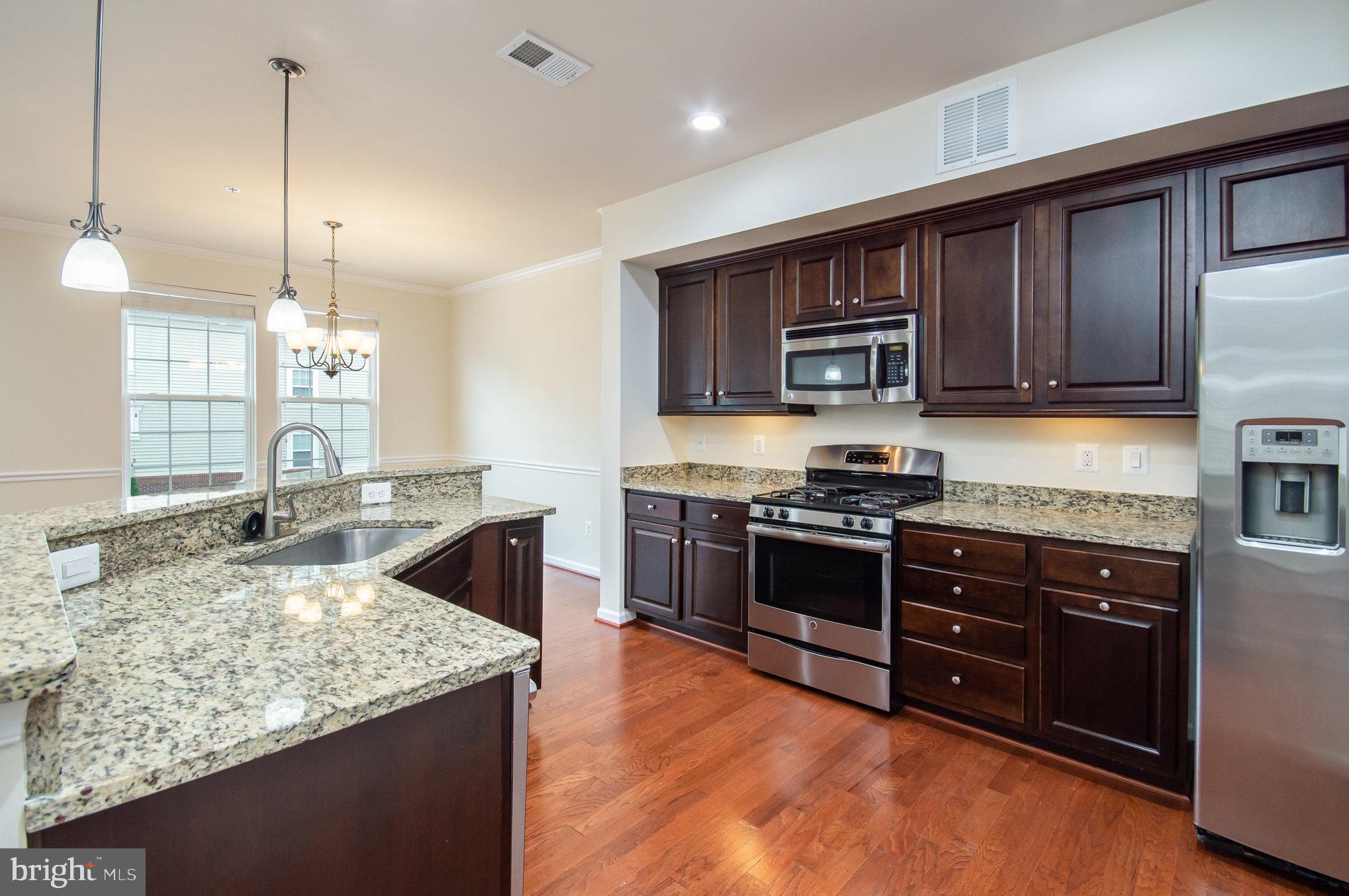 4722 Dane Ridge Circle Woodbridge, VA 22193 - Photo 7 of 28 a kitchen with stainless steel appliances granite countertop a stove refrigerator and a sink