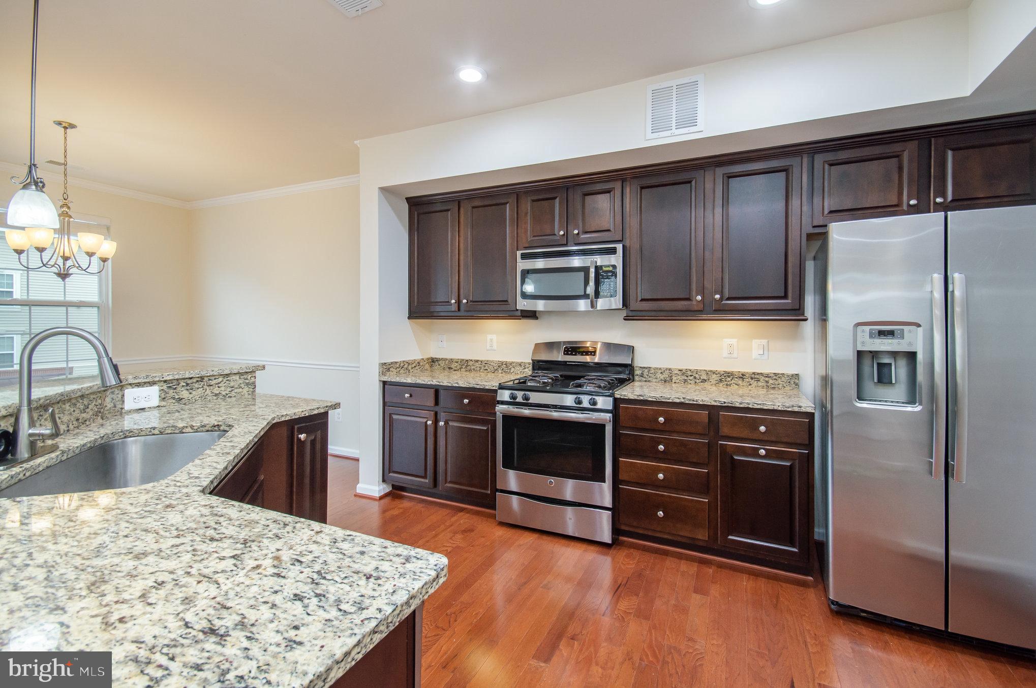4722 Dane Ridge Circle Woodbridge, VA 22193 - Photo 9 of 28 a kitchen with stainless steel appliances kitchen island granite countertop a refrigerator stove and sink