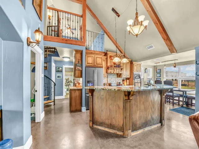 a living room with stainless steel appliances granite countertop furniture and a kitchen view