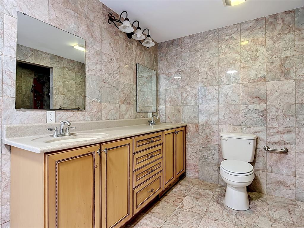 7925 Lake Mabel Loop Road Lake Wales, FL 33898 - Photo 37 of 97 a spacious bathroom with a granite countertop toilet sink and mirror