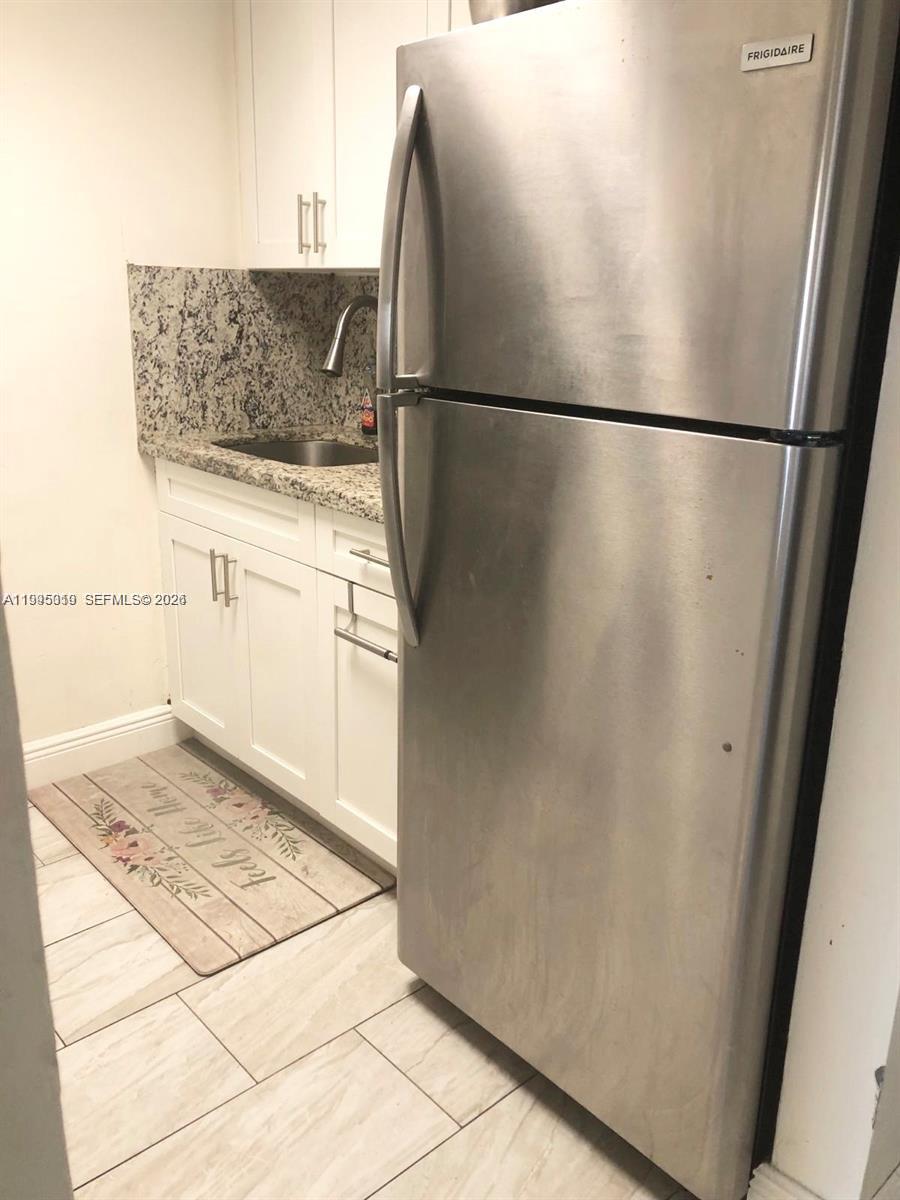 777 Southwest 9th Avenue, Unit 411 Miami, FL 33130 - Photo 3 of 14 a view of a refrigerator in kitchen and wooden floor
