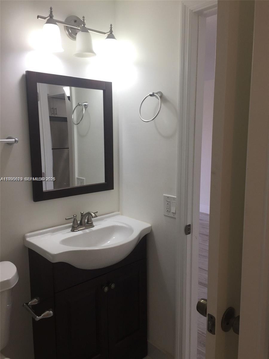 777 Southwest 9th Avenue, Unit 411 Miami, FL 33130 - Photo 7 of 14 a bathroom with a toilet sink and mirror