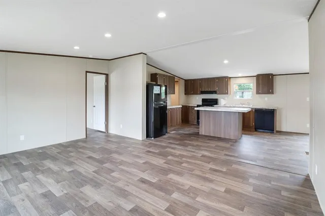 a view of kitchen with stainless steel appliances wooden floor and large window
