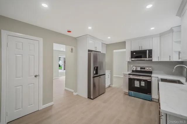 a kitchen with stainless steel appliances granite countertop a refrigerator and a stove top oven