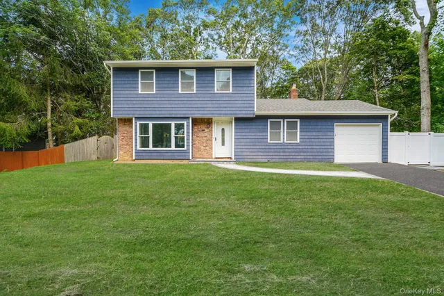 a view of a house next to a big yard and large trees