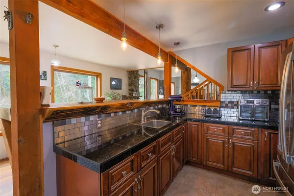 a kitchen with granite countertop a sink and a stove