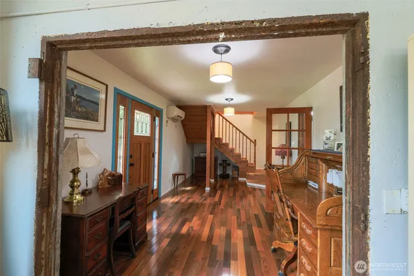 a view of a hallway with wooden floor and entryway