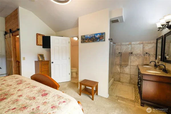 a bedroom with a bed and a view of living room