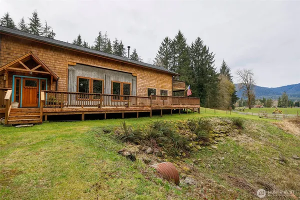 a backyard of a house with wooden deck and barbeque oven