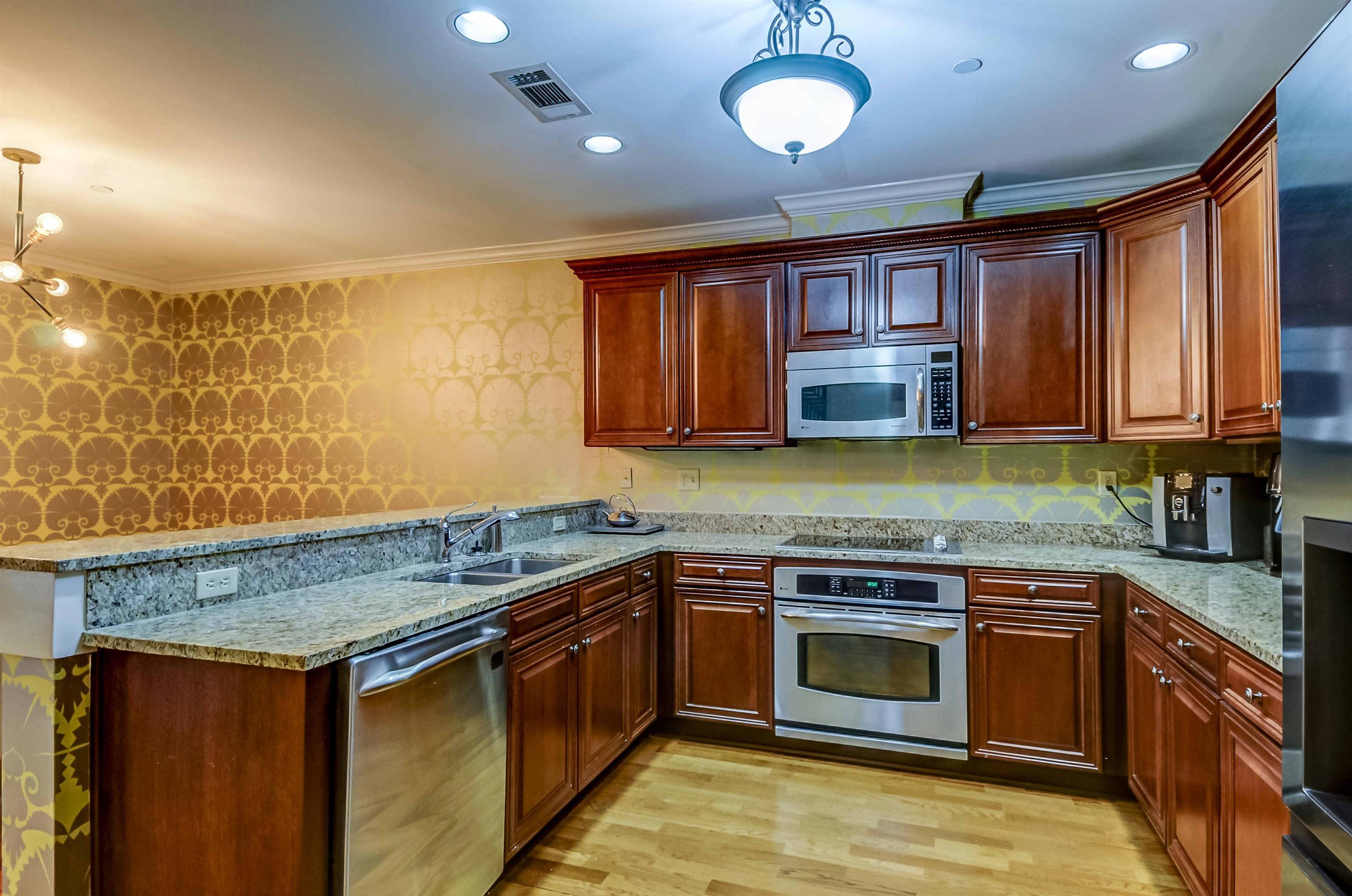 591 Lexington Road, Unit 303 Memphis, TN 38117 - Photo 16 of 34 a kitchen with stainless steel appliances granite countertop wooden cabinets stove top oven and sink
