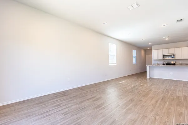 a view of a livingroom and a kitchen with wooden floor