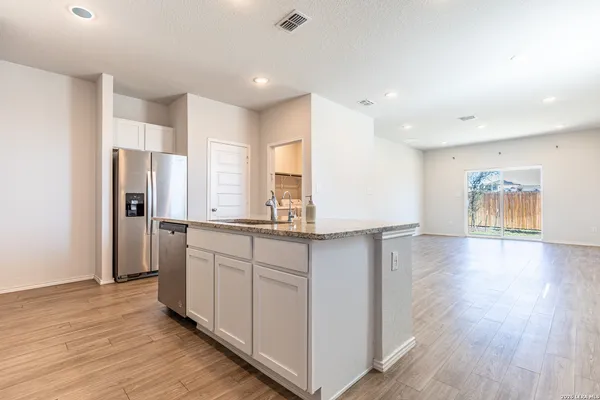 a kitchen with stainless steel appliances a refrigerator and a stove top oven