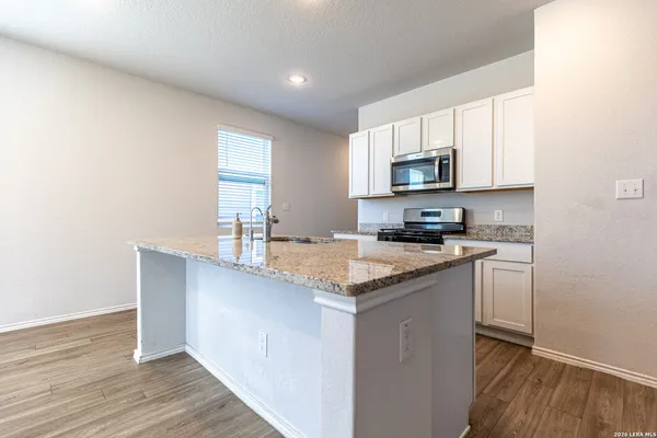 a kitchen with stainless steel appliances granite countertop a stove a sink and a microwave