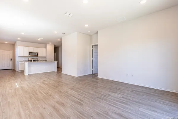 a view of kitchen with refrigerator stove and wooden floor