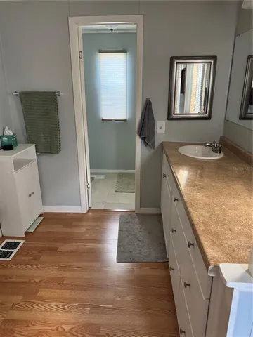 a bathroom with a granite countertop toilet sink and mirror