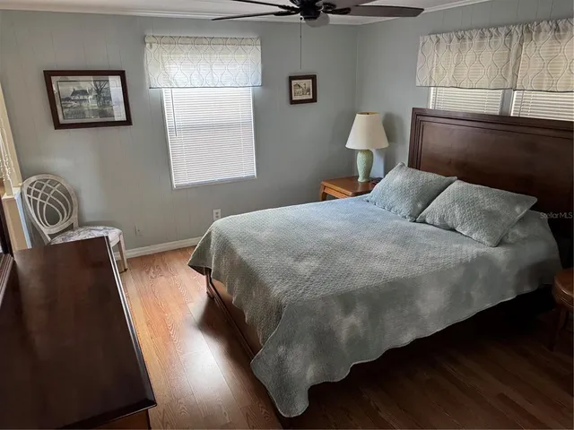 a bedroom with a bed and wooden floor