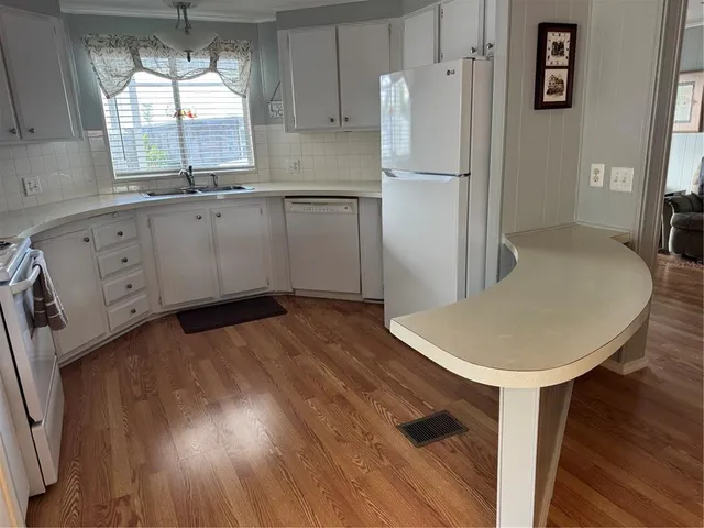a kitchen with kitchen island a counter top space a sink and appliances