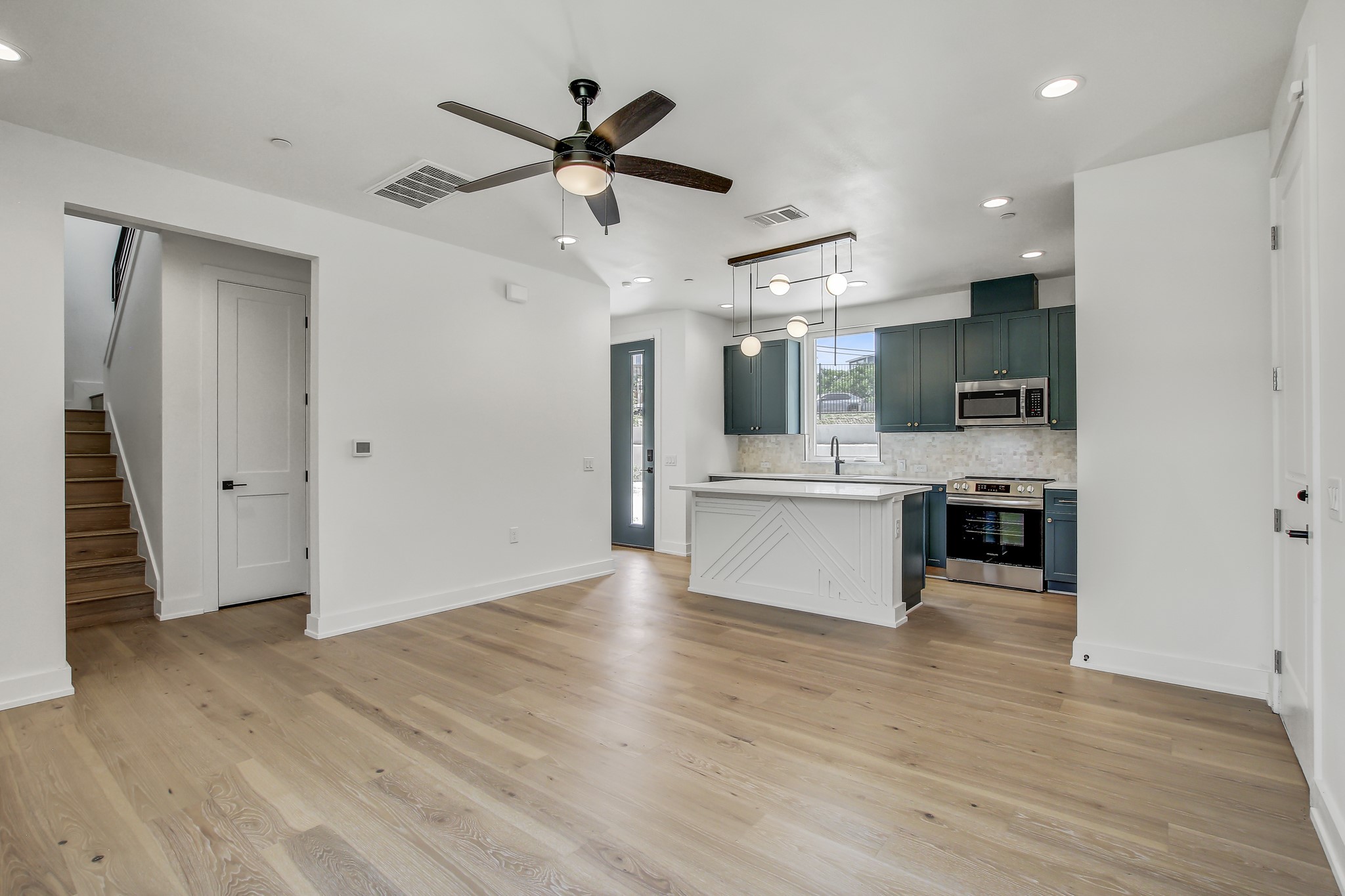 4127 East 12th Street, Unit 5 Austin, TX 78721 - Photo 5 of 33 Kitchen with appliances with stainless steel finishes, light countertops, a ceiling fan, tasteful backsplash, and recessed lighting