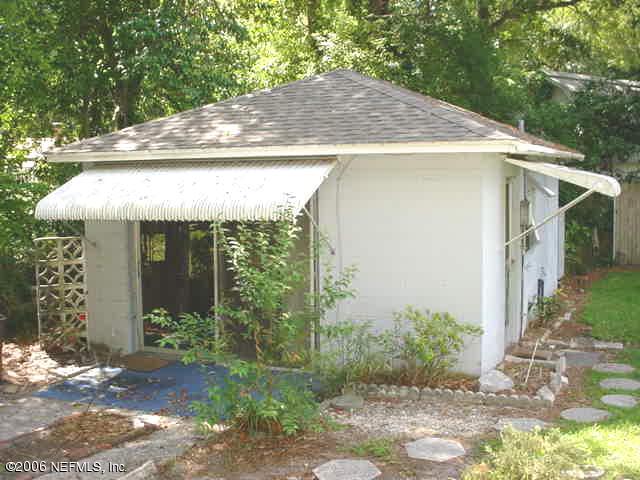 4824 Manchester Road Jacksonville, FL 32210 - Photo 7 of 10 a view of a house with a small yard plants and large tree